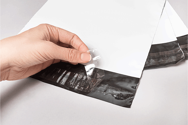 Striscia di carta siliconata applicata in linea su confezioni per e-commerce in pellicola facilmente staccabile