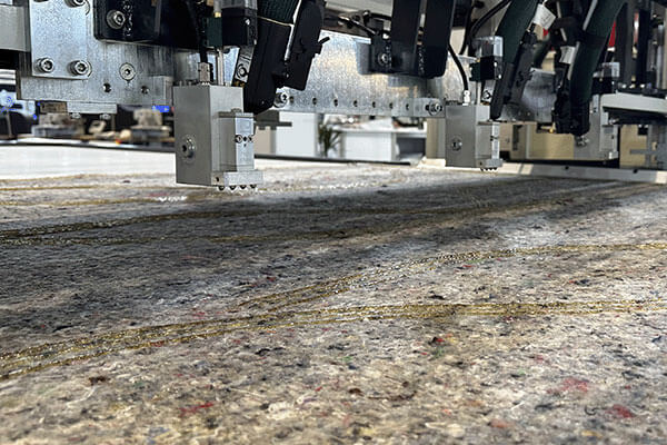 Robatech’s Duero application head applying hot melt beads for gluing felt pads.