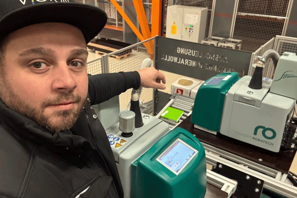 Iraido Payne, tecnico dell'assistenza presso Robatech Germania, davanti a due fusori per adesivi Concept Stream