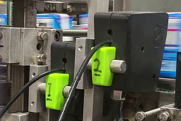 Due pistole elettromagnetichee Volta per l'applicazione della cannuccia sulle confezioni delle bibite
