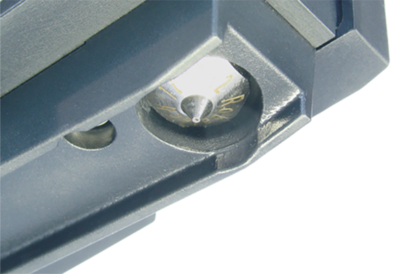 Sicht von unten auf die Klebstoff-Auftragsdüse mit Düsenschutz aus Aluminium