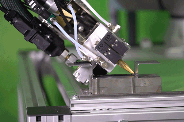 Zweifach-Dosierkopf Primo über Integrationskit mit Roboterarm verbunden. Variante für Raupenauftrag.