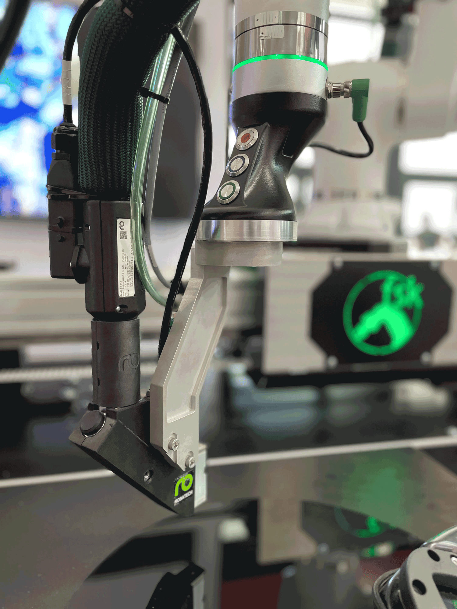 Roboterarm mit Griffstück für Lead Through Programming und Auftragskopf Delta von Robatech für Klebstoffauftrag 