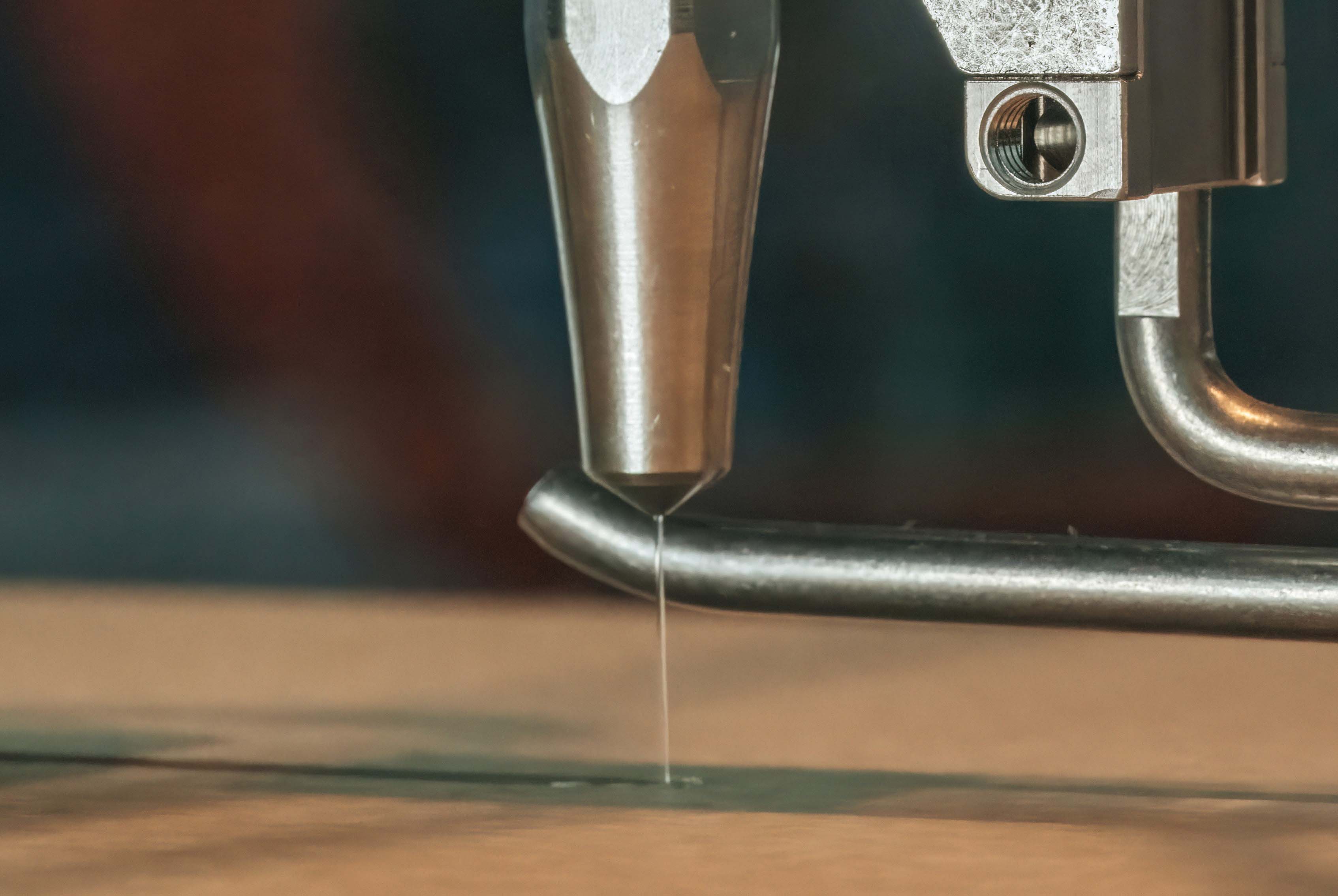 Spritzkopf Sempre 30 trägt Rillflüssigkeit SpeedUp auf Wellpappe auf