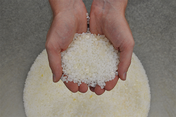 Two hands holding adhesive granules