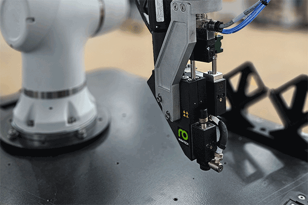 Auftragskopf Delta mit der Halterung des Integrationskits am Roboterarm befestigt.