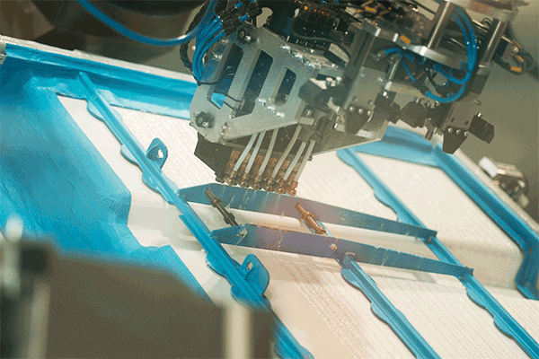 Mehrfachkopf Aero beim Klebstoffauftrag auf Batterieabdeckung