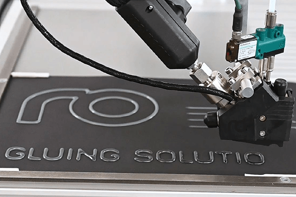 360° Gluing: Adhesive application head writes letters using adhesive