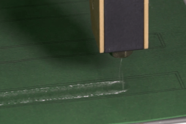 360° Gluing: Klebstoff-Kringelauftrag auf Papier, randgenau in markiertem Rahmen